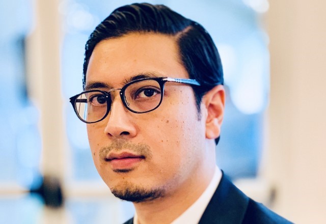 Close-up professional headshot of Dr. Brijen Joshi, wearing glasses and a dark suit, looking directly at the camera.